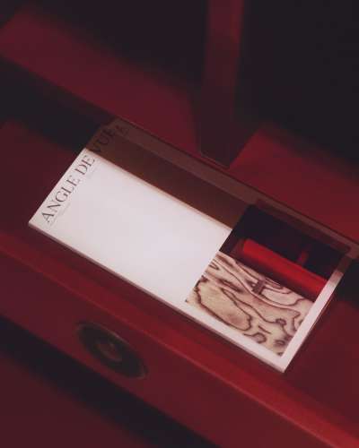 Editorial publication “Angle de Vue” by Philippe Hurel placed inside a red leather furniture piece, highlighting material, texture and spatial context.