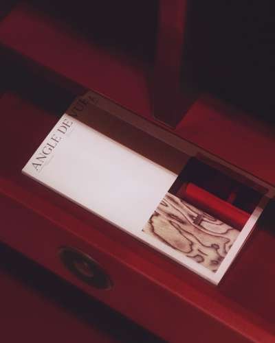 Editorial publication “Angle de Vue” by Philippe Hurel placed inside a red leather furniture piece, highlighting material, texture and spatial context.